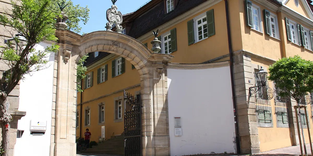 A stone archway with a building behind, in Germany.