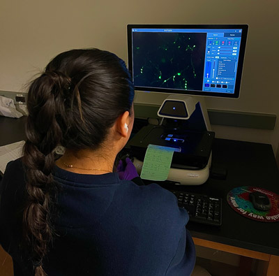 Jessenya working with equipment in the lab.