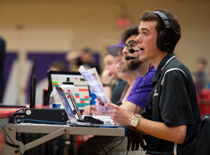 Joe Stuart ’19, calls play-by-play in a men’s basketball game for the Linfield Sports Network.