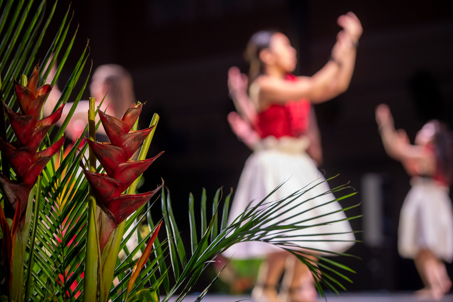 dancers on the stage at the lu'au surrounded by Hawaiian floral decorations