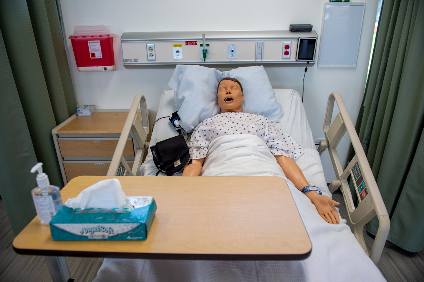 Adult manikin in a hospital bed in the simulation lab.