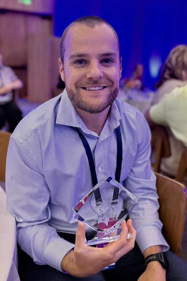 Brandon holding his award.