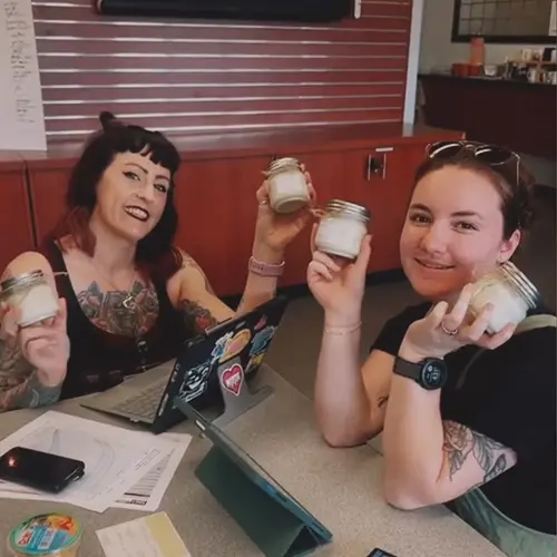 two students showing off candles they made.