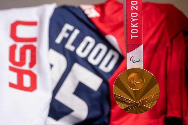 Annie Flood's Olympic Medal with her sitting volleyball journey in the background