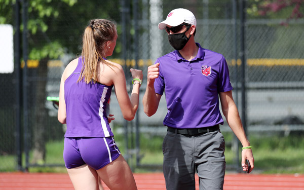 Josh coaching female student-athlete during track meet