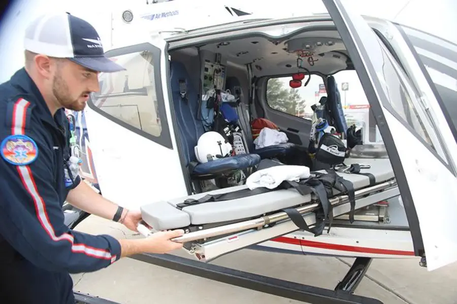 Josh loading an empty stretcher into a helicopter.