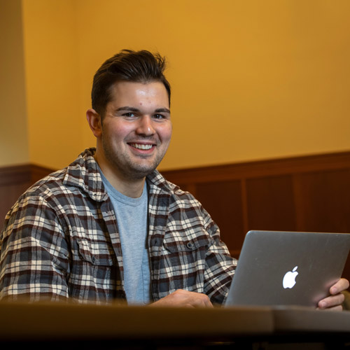 Kaden Gass '22 working on his laptop in T.J. Day Hall