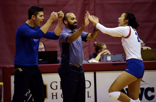 Kaden celebrating with the volleyball coach and player with cheers and high fives after a successful play