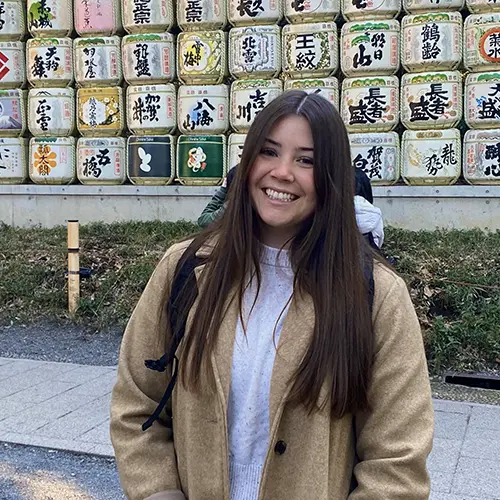 Mariah posing in front sake barrels.