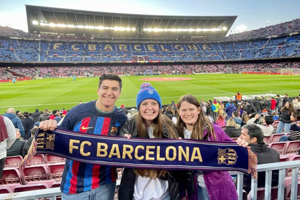 Meghan with two friends at a football game in Barcelona.