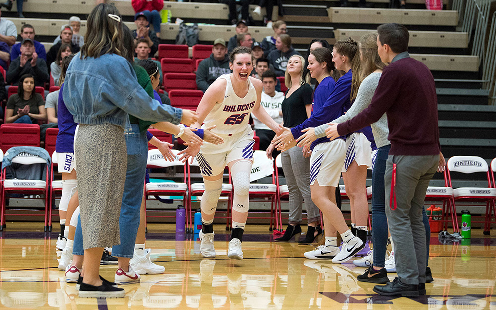 Molly entering a game to high-fives from her teammates