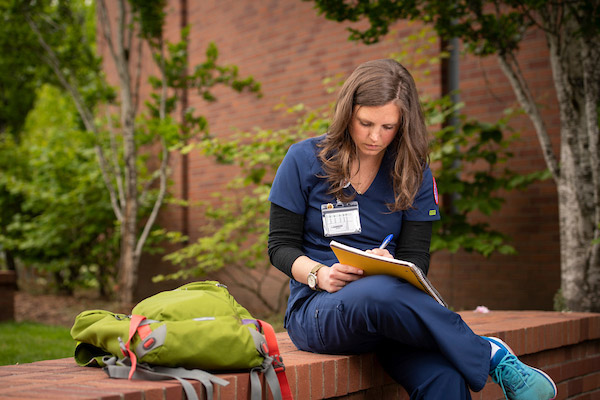 Nicole Hale '22 studying outside on a bench on Linfield's Portland campus