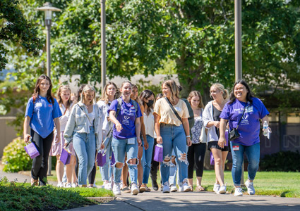A group of nursing students walking on a path through the Portland campus.