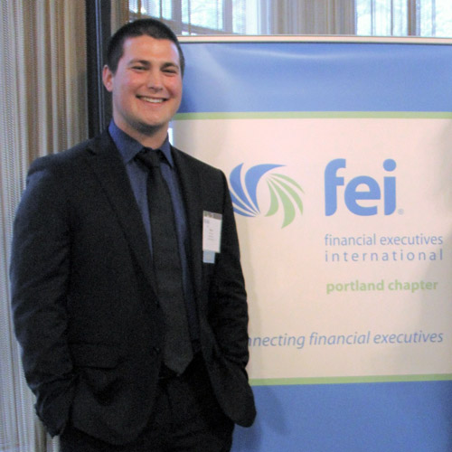 Owen Hand '24 in front of an FEI banner.