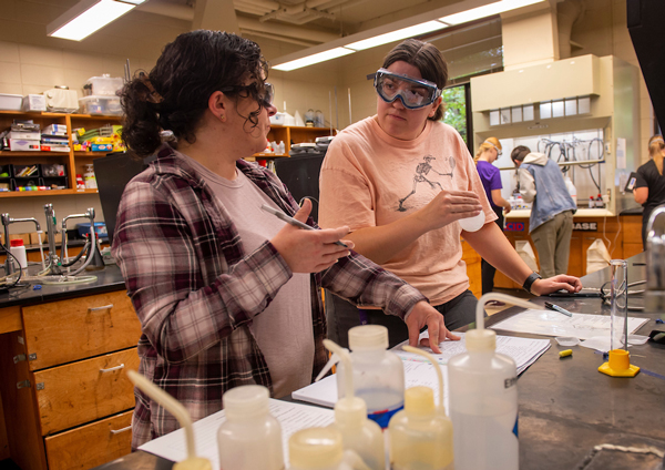 Chemistry Lab Coordinator Veronica Siller '10 working in the lab with a student.