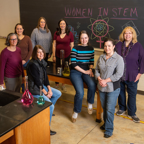 Eight of Linfield's female STEM faculty members in a science lab.