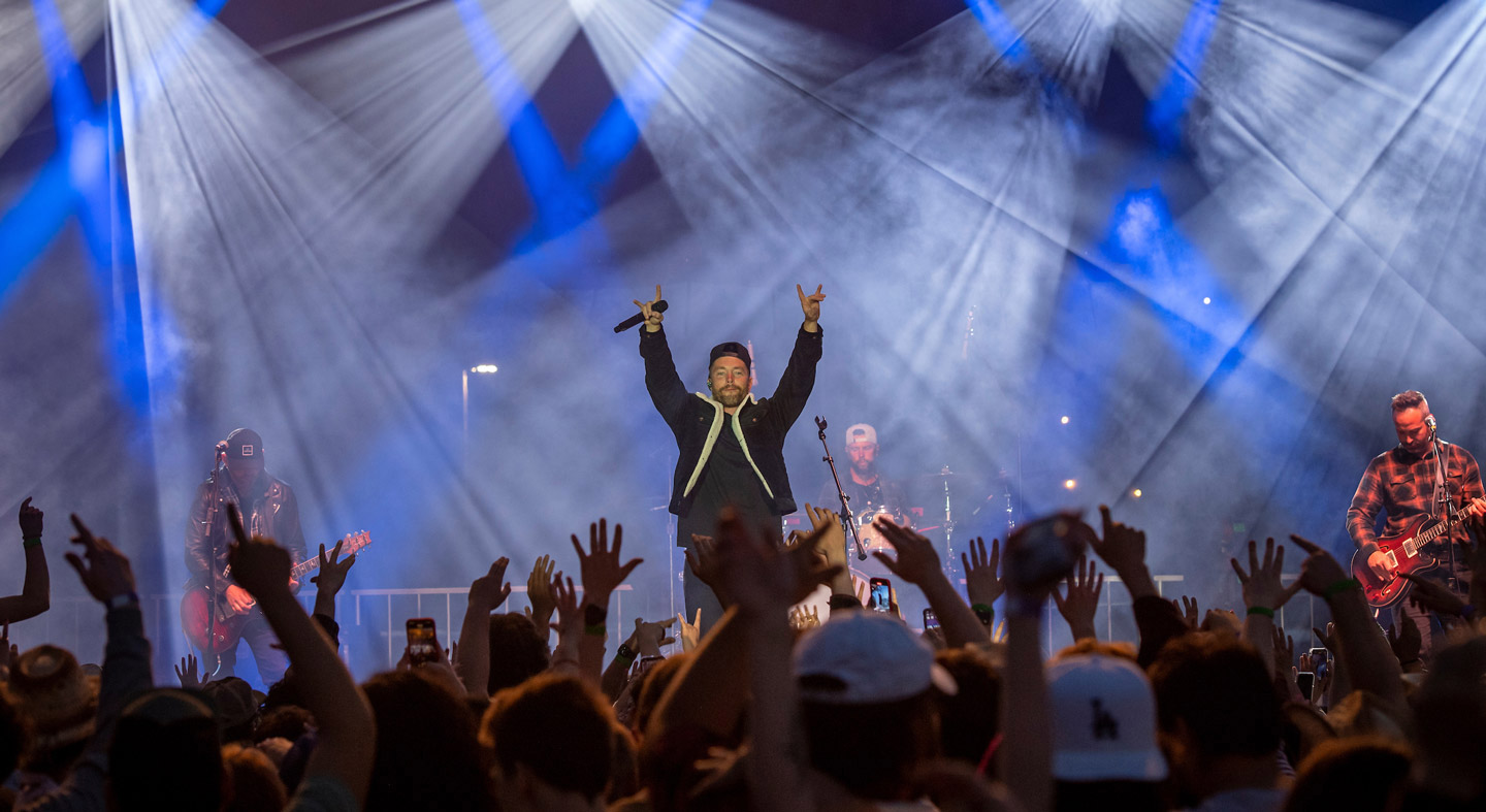 Country singer Chris Lane performing on stage for a crowd of students at Linfield's annual concert event, Wildstock.