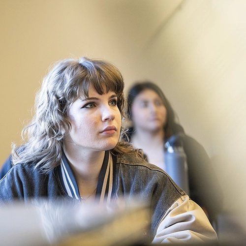 A student listening to a lecture in a class.