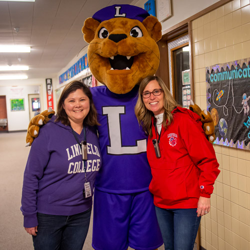 Two Linfield alumni who are now teachers with Mack the Wildcat.