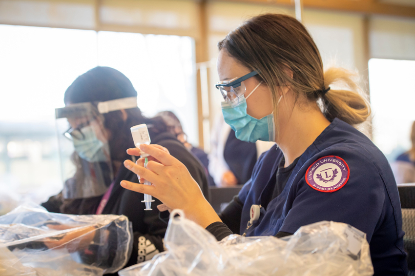 Nursing student wears mask and practices administering vaccine