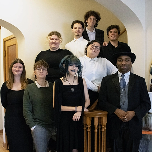 The directors for The Dining Room posing on a set of stairs.