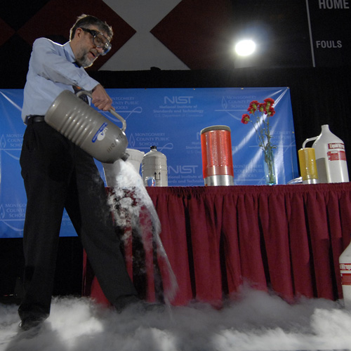 Bill Phillips performing an experiment with chemicals on stage.