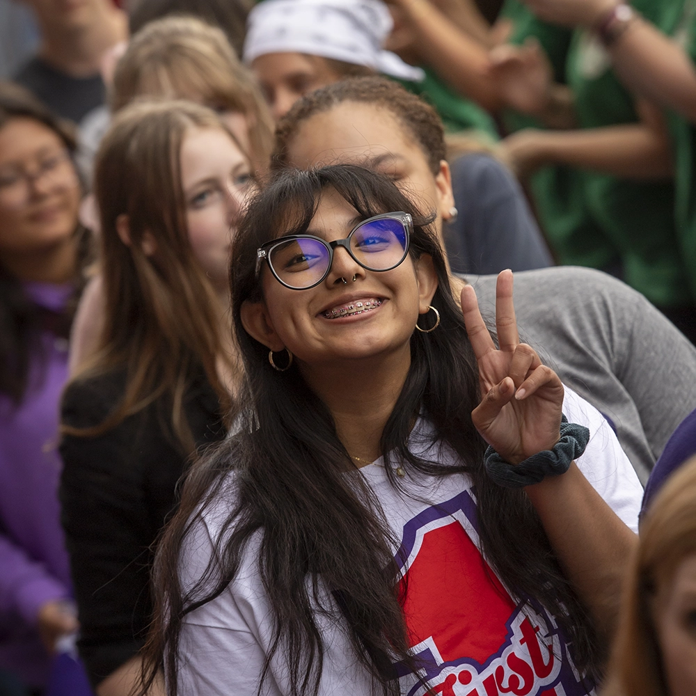 a student giving a peace sign while walking into Cat Camp.