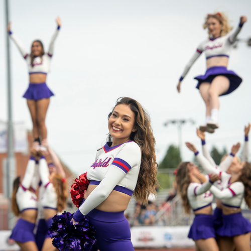 Linfield Cheer and dance team performing at a football game.