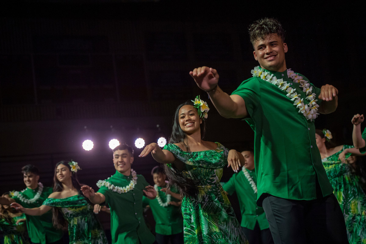 A dance performance, students are wearing green.
