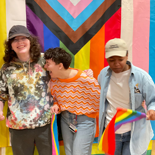 Three McMinnville students posing in a photo booth during Pride Week celebrations.