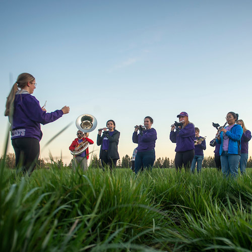 The Marching Band performing in a field at art event