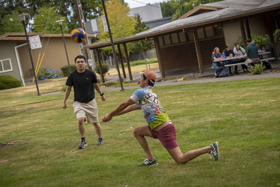 students playing volleyball outside.