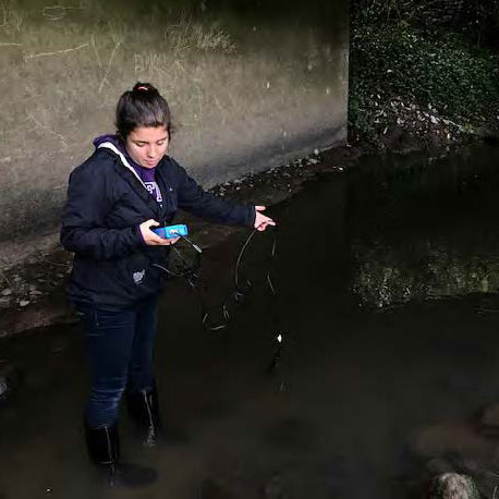 student collecting water quality data at research site