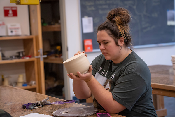 student making pottery