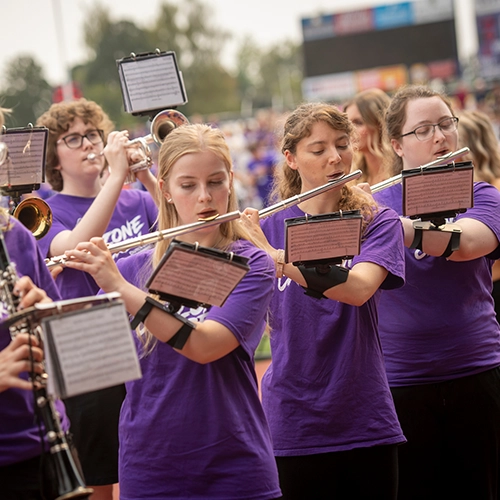 students performing in the band at a football game.