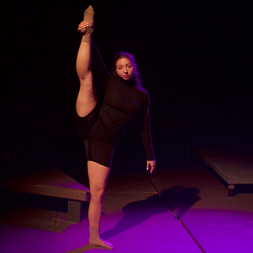 two students dancing on a dimly lit stage