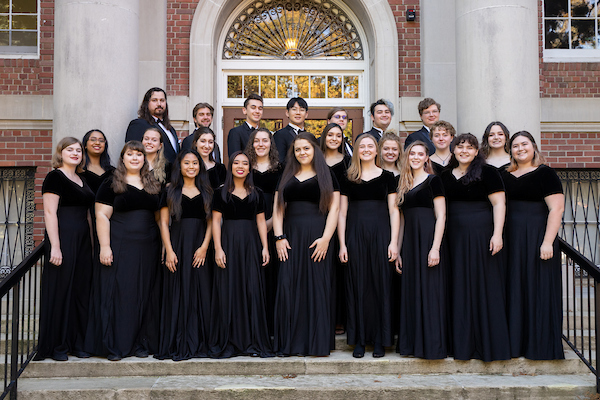 Members of Linfield's Concert Choir in formal performance attire standing on the front steps of Melrose Hall.