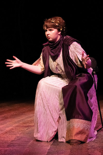 Linfield Theatre student as Diane in Greek robe on stage.