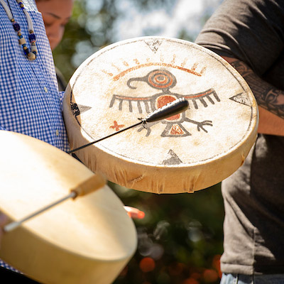 three members of the Confederated Tribes of Grande Ronde performing a blessing song using traditional Native American hand drums