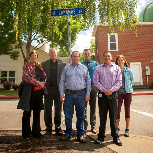 Six members of the committee naming Lakamas Lane pictured under the new street sign.