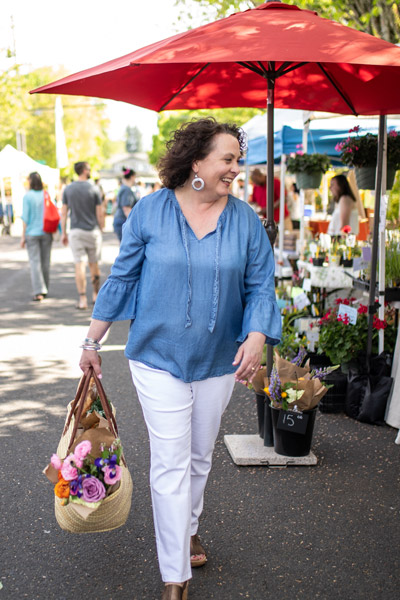 Maria Stuart walking through a farmers market.