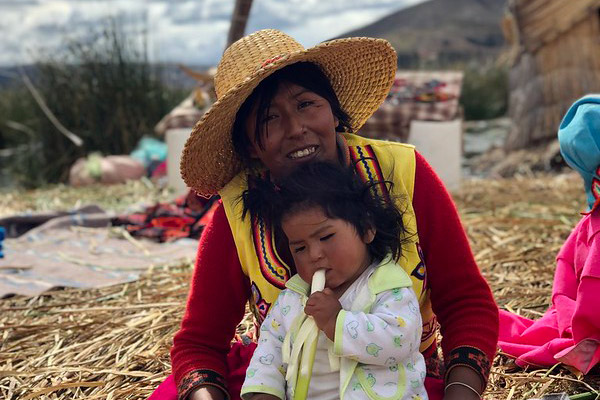 A mother with young child sitting on her lap in Peru