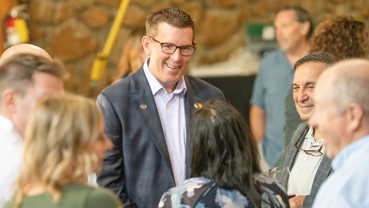 Prsident Blegen talking to a group of people at an event