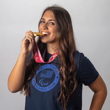 Annie Flood '25 biting her Olympic gold medal