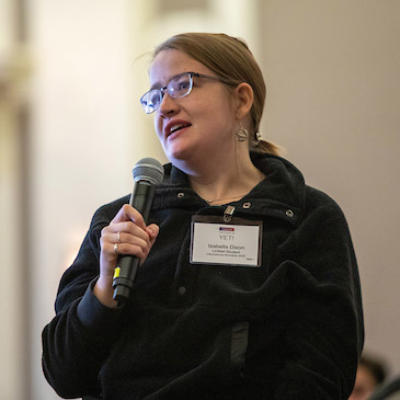 Linfield business student holding microphone asking a question during the symposium.