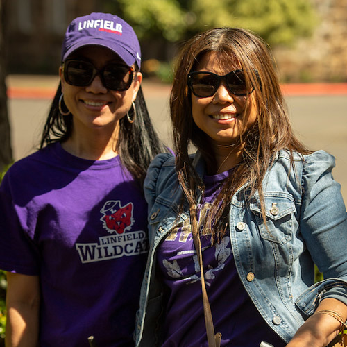 Female student with her mother, both wearing Linfield gear.
