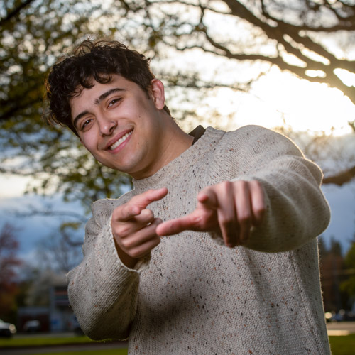 happy male student pointing at the camera