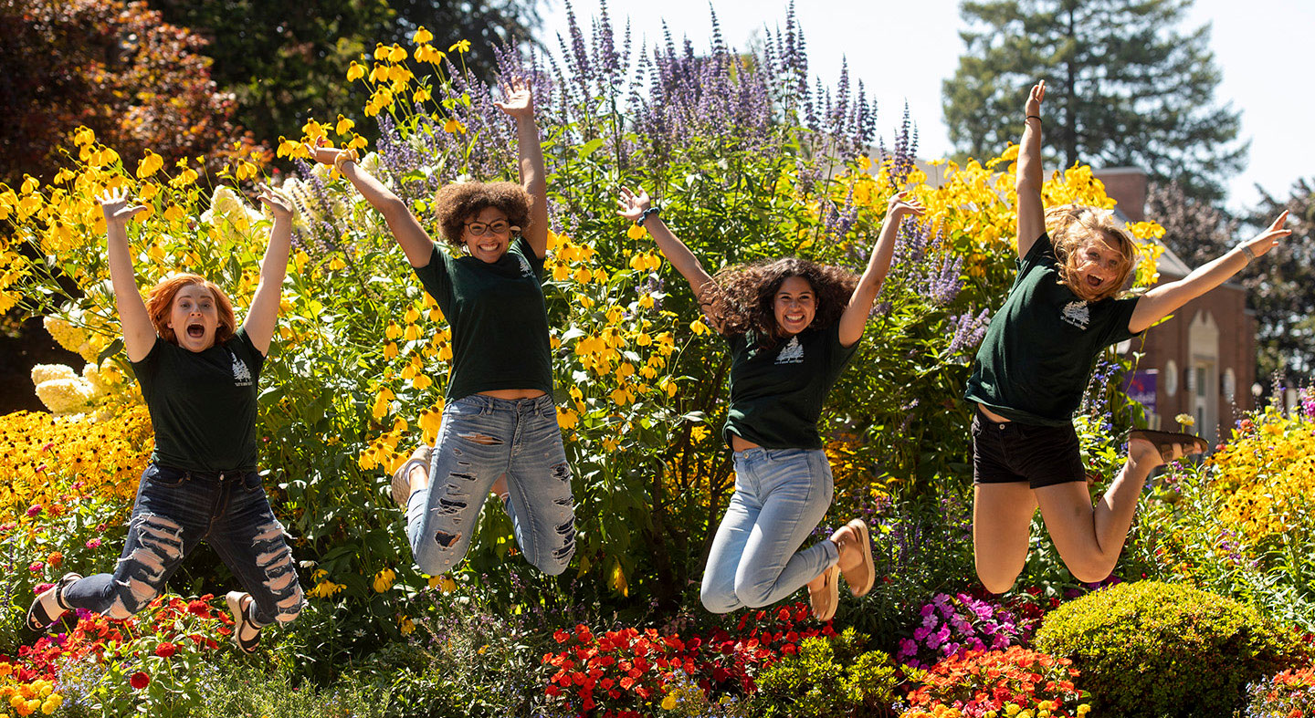 four Linfield students jumping with excitement