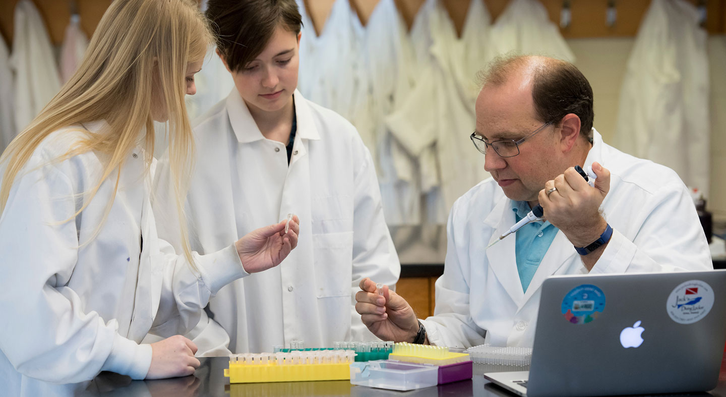 Professor Weisz in lab with two students.