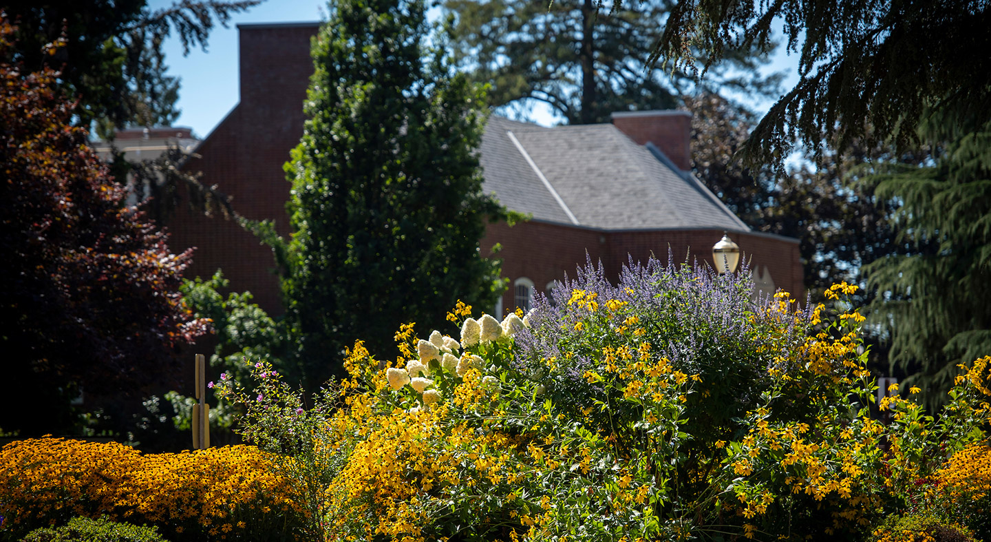 The front of TJ Day Hall with flowers in bloom.